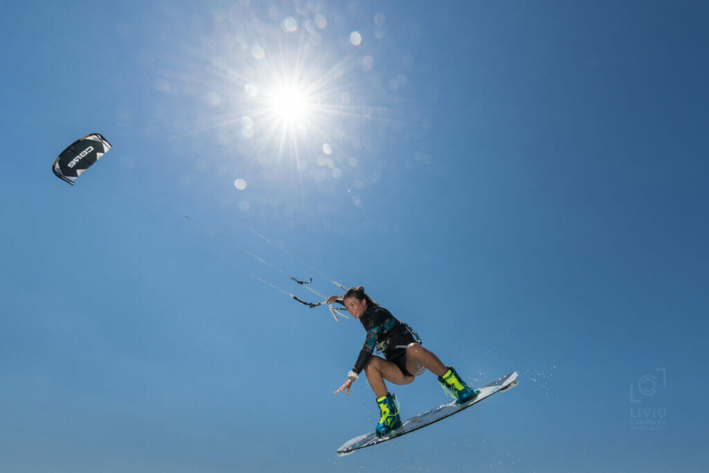 Frau in der Luft beim Kitesurfen