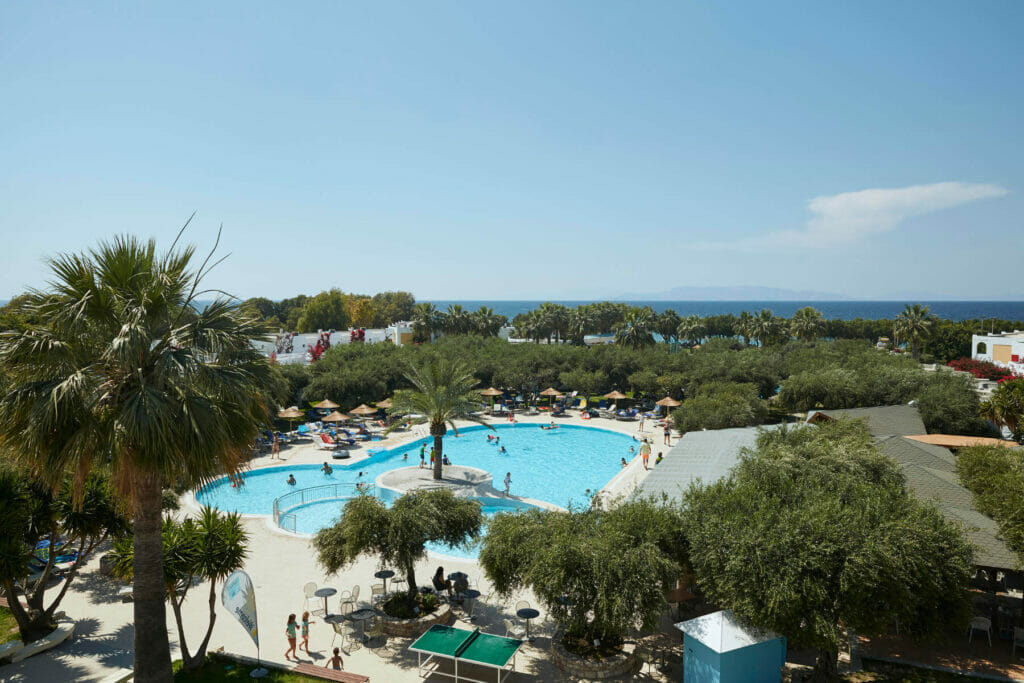 Hotel with pool and palm trees in Theologos
