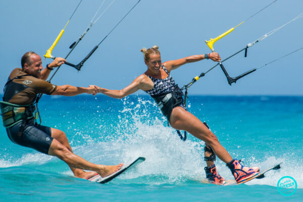 Zwei Kitesurfer beim Händehalten in Trianda