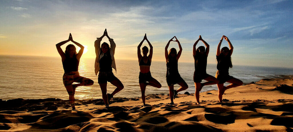 Yoag group on dune at sunset, Morocco